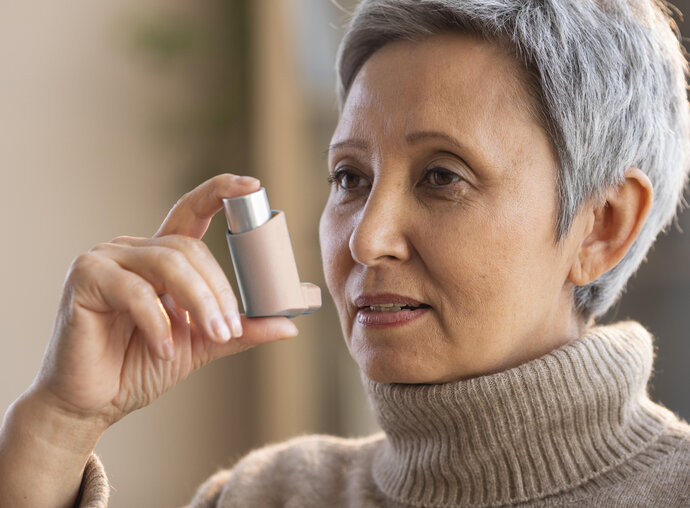 Senior woman holding an asthma inhaler